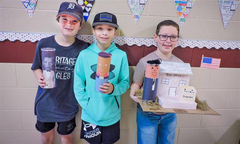 Students hold up Characters in a Can